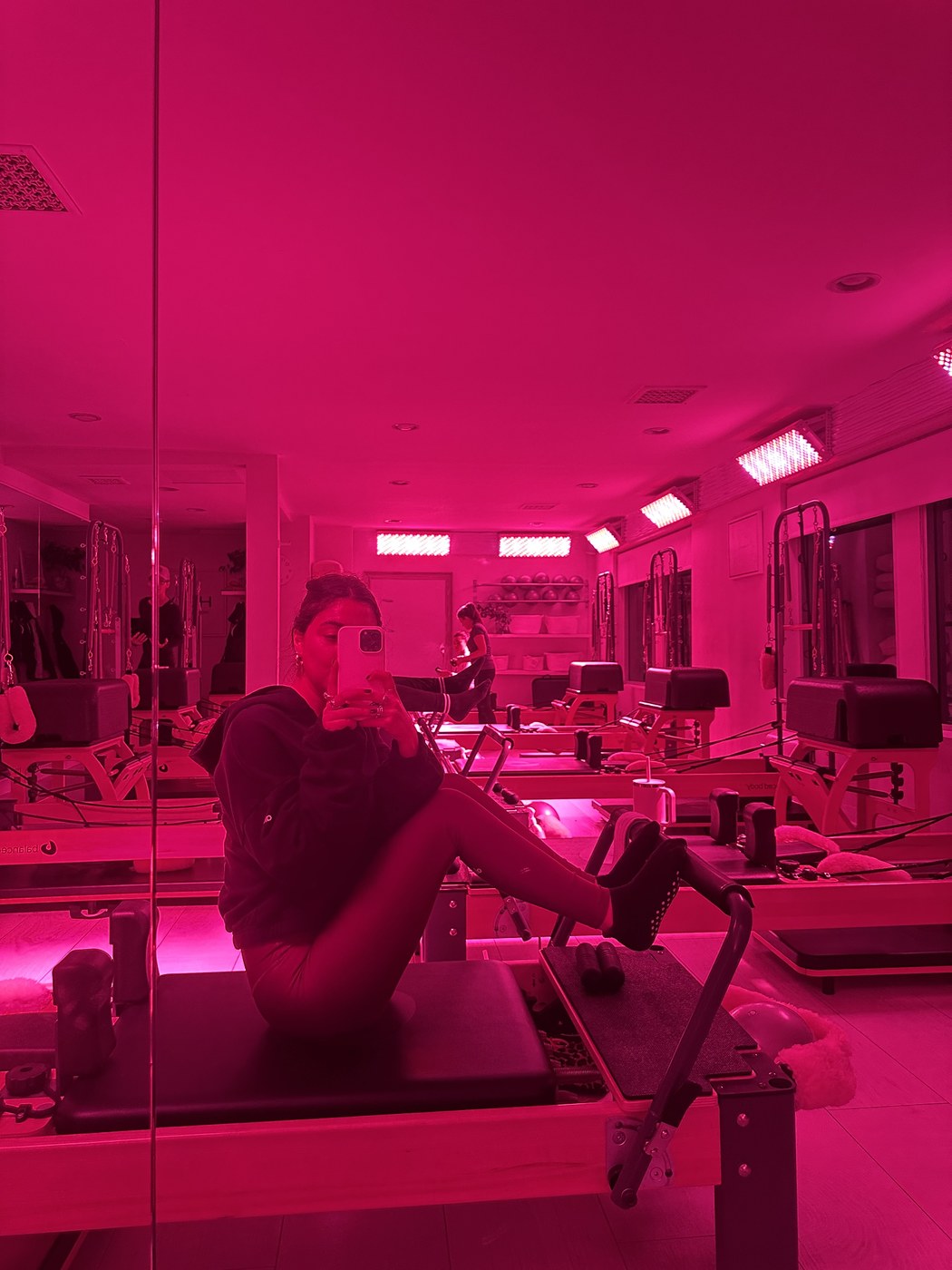 Pink-lit Pilates reformer studio